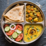 Colorful vegetarian tiffin box with chapati, sabzi, salad and dal