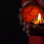 depicting the ritual of lighting a traditional oil lamp for Yama Deepam