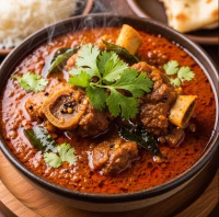 spicy Mysore mutton curry garnished with fresh coriander