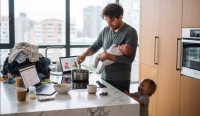 Stressed parent multitasking in modern kitchen